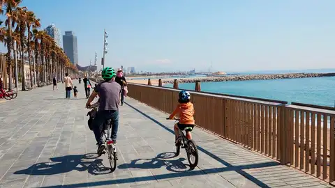 Una familia circula en bici por el paseo marítimo de Barcelona Una familia circula en bici por el paseo marítimo de Barcelona