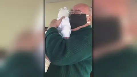 Anciano emocionado al conocer a su bisnieto Anciano emocionado al conocer a su bisnieto