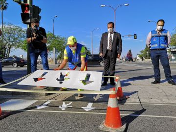 Operarios del Ayuntamiento de Sevilla pintan flechas en un paso de cebra