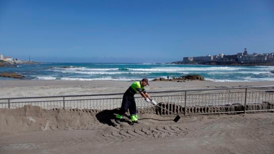 Un operario del concello de A Coru&ntilde;a trabaja en el acondicionando la playa de Riazor