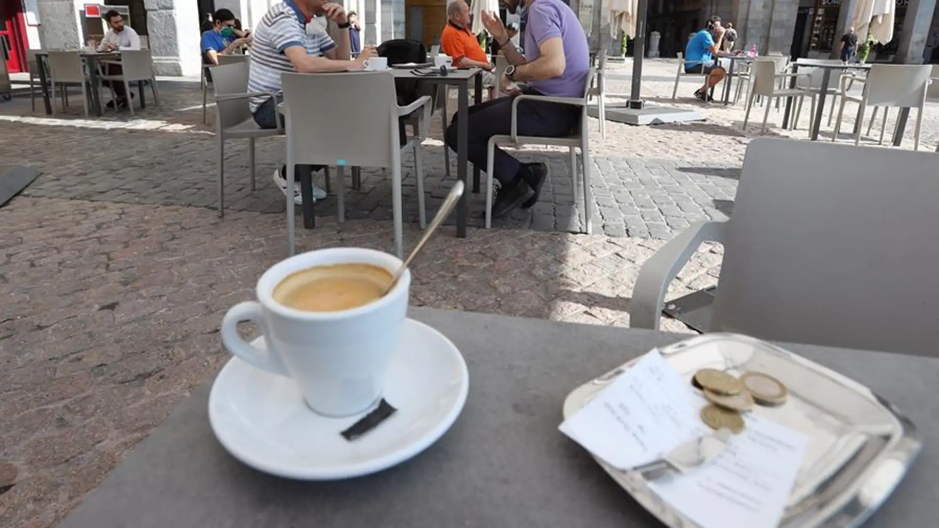 Varias personas disfrutan de la terraza de un bar.