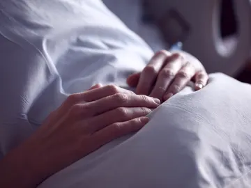 Un paciente recostado en una cama de hospital Un paciente recostado en una cama de hospital