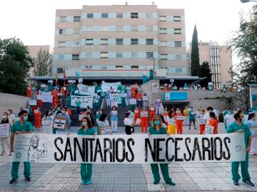 Sanitarios del Hospital Gregorio Marañón posan con una pancarta en la que se lee "Sanitarios necesarios"