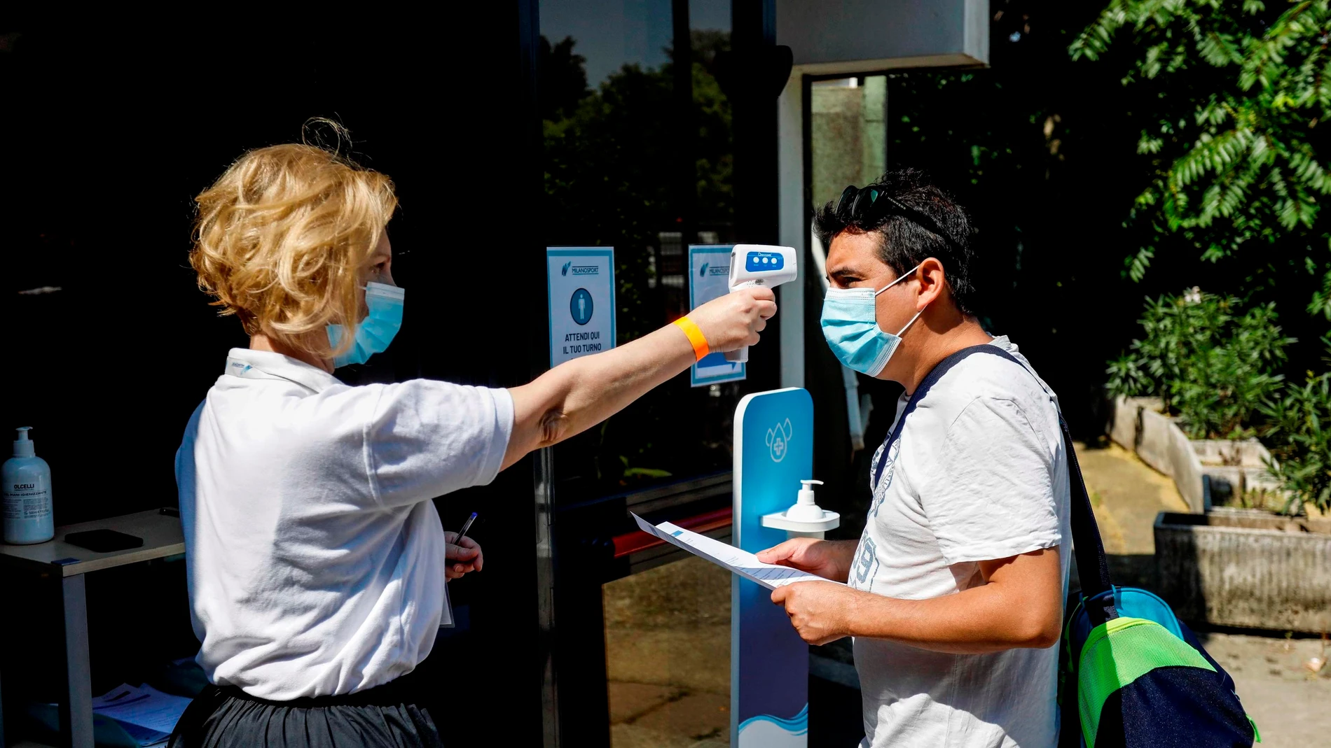 Toma de temperatura a un ciudadano italiano en la entrada a una piscina Toma de temperatura a un ciudadano italiano en la entrada a una piscina