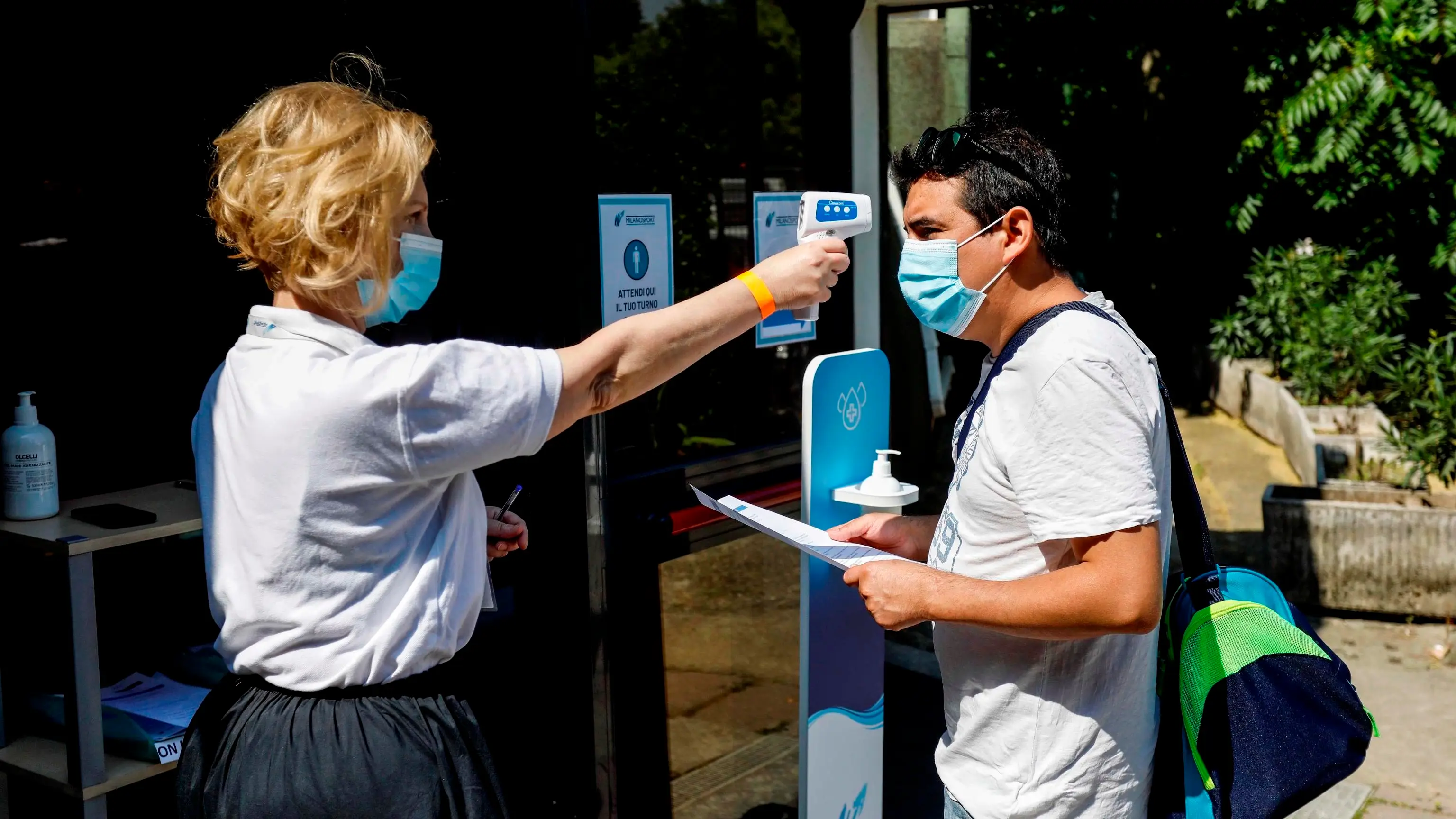Toma de temperatura a un ciudadano italiano en la entrada a una piscina