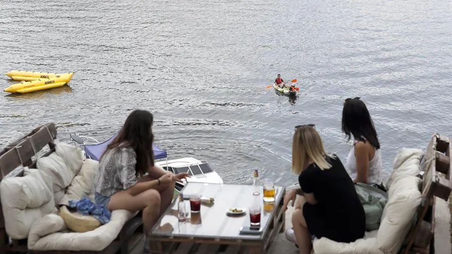 Varias personas en una terraza en el Pantano de San Juan (Madrid).