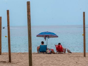 Una pareja disfruta del buen tiempo en la playa de Palmanova de Calviá, Mallorca