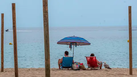 Una pareja disfruta del buen tiempo en la playa de Palmanova de Calviá, Mallorca Una pareja disfruta del buen tiempo en la playa de Palmanova de Calviá, Mallorca