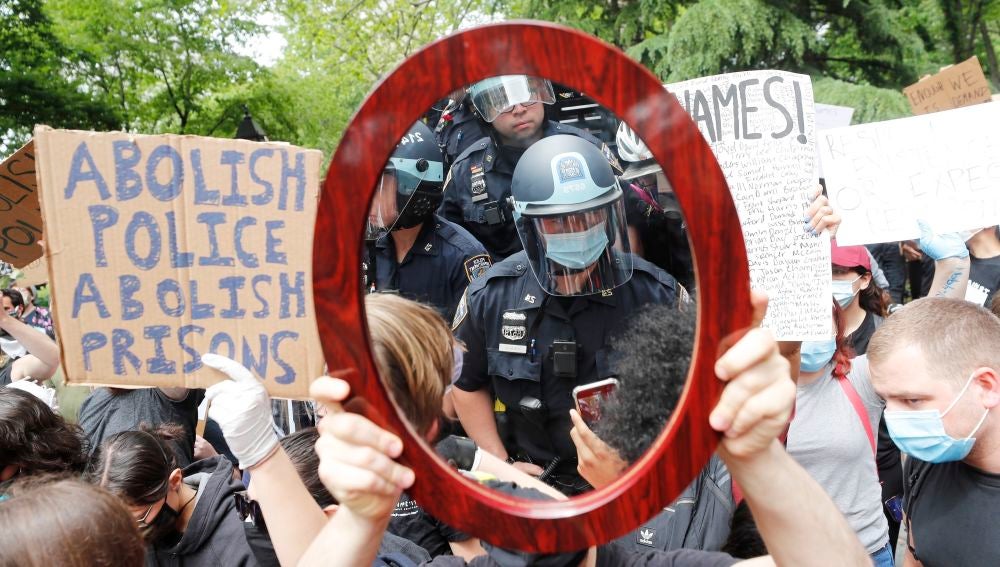 Un oficial de policía de Nueva York reflejado en el espejo de un manifestante