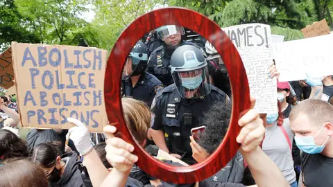 Un oficial de policía de Nueva York reflejado en el espejo de un manifestante Un oficial de policía de Nueva York reflejado en el espejo de un manifestante
