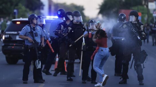 Una agente de Polic&iacute;a roc&iacute;a con gas pimienta a una manifestante en Minneapolis