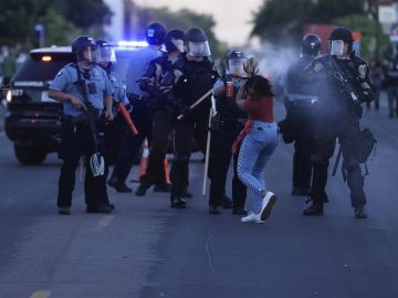 Una agente de Policía rocía con gas pimienta a una manifestante en Minneapolis