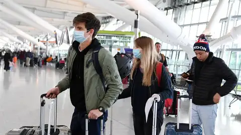 Pasajeros con mascarilla en un aeropuerto Pasajeros con mascarilla en un aeropuerto