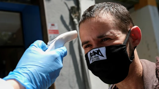 Toman la temperatura a un vecino de Barcelona con mascarilla de tela Toman la temperatura a un vecino de Barcelona con mascarilla de tela