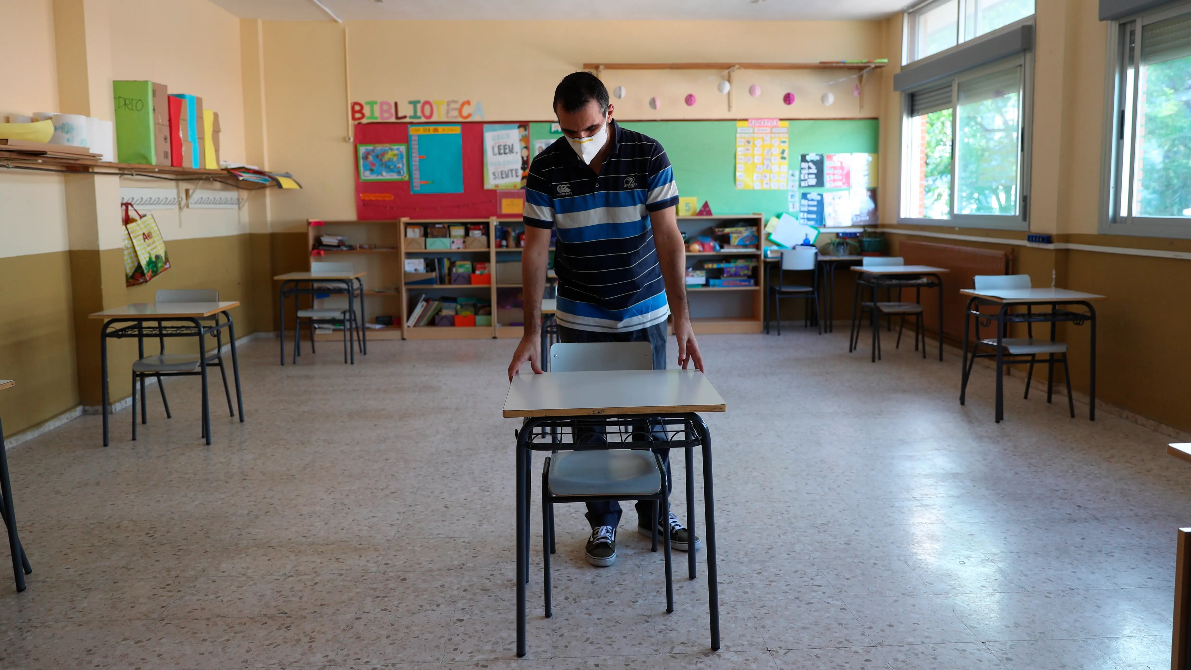 Un profesor coloca las mesas para mantener la distancia de seguridad En Madrid