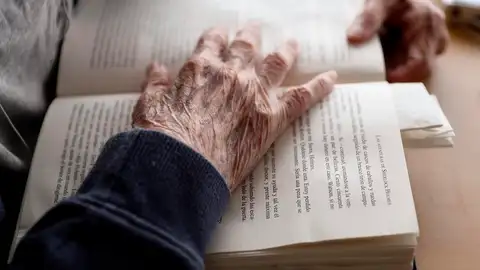 Un anciano lee un libro en una residencia de Madrid Un anciano lee un libro en una residencia de Madrid