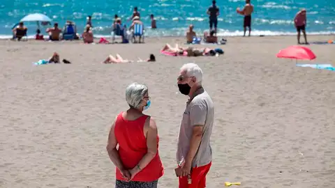 Personas con mascarilla en una playa Personas con mascarilla en una playa (Archivo)