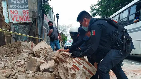 Policías y agentes de protección civil retiran escombros de una fachada derruida en Oxaca Policías y agentes de protección civil retiran escombros de una fachada derruida en Oxaca