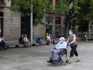 Dos personas pasean con mascarilla