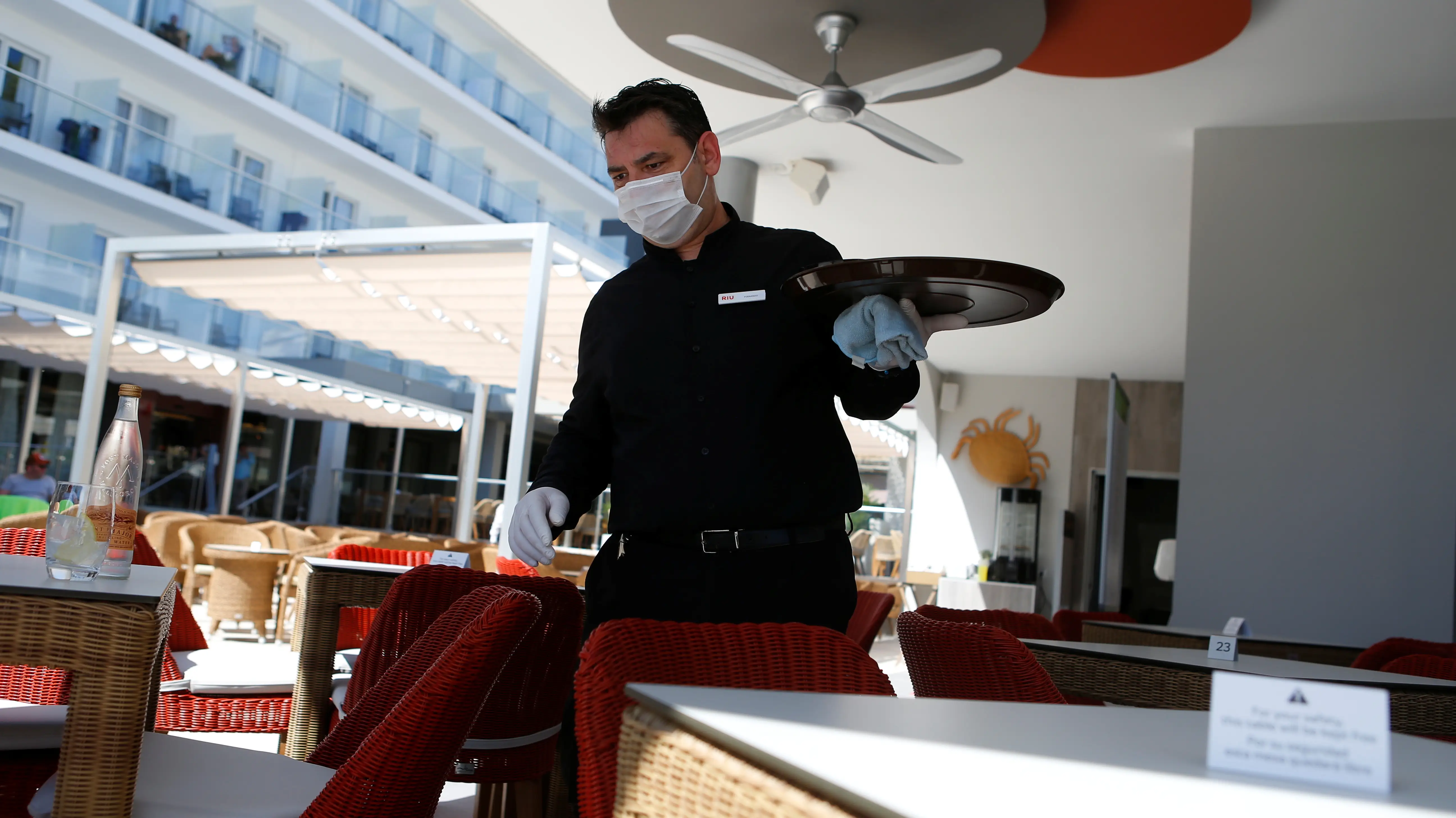 Un camarero trabajando mientras usa mascarilla facial contra el coronavirus