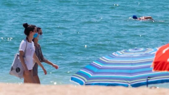 Dos j&oacute;venes con mascarilla, obligatoria en las playas de Andaluc&iacute;a