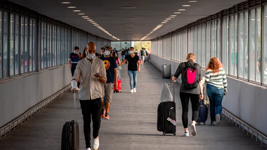 Varios pasajeros en uno de los pasillos de la T2 del Aeropuerto de El Prat Varios pasajeros en uno de los pasillos de la T2 del Aeropuerto de El Prat