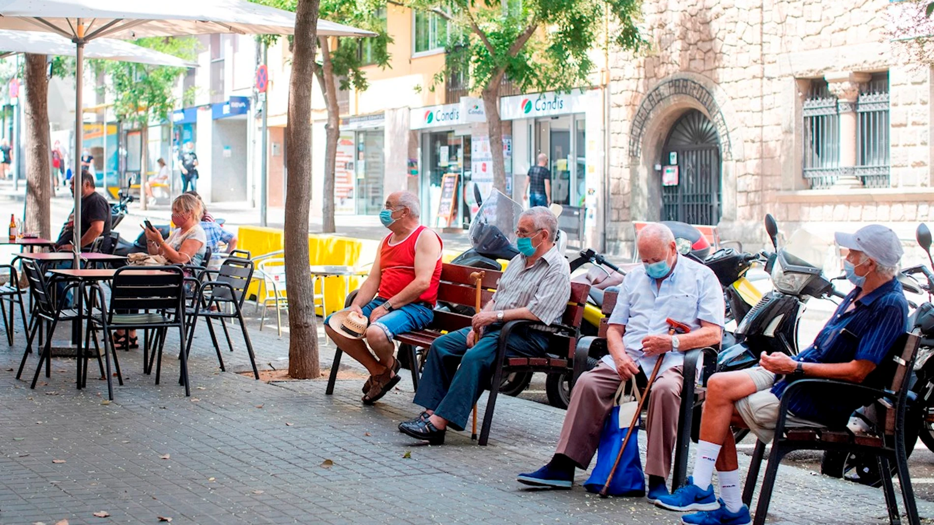 Gente con mascarillas en una calle del barrio de El Carmel de Barcelona Gente con mascarillas en una calle del barrio de El Carmel de Barcelona
