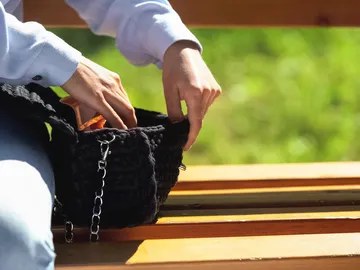 Una mujer revisa su bolso Una mujer revisa su bolso