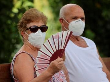 Varias personas descansan en la zona de Madrid Río, en la capital con mascarilla 