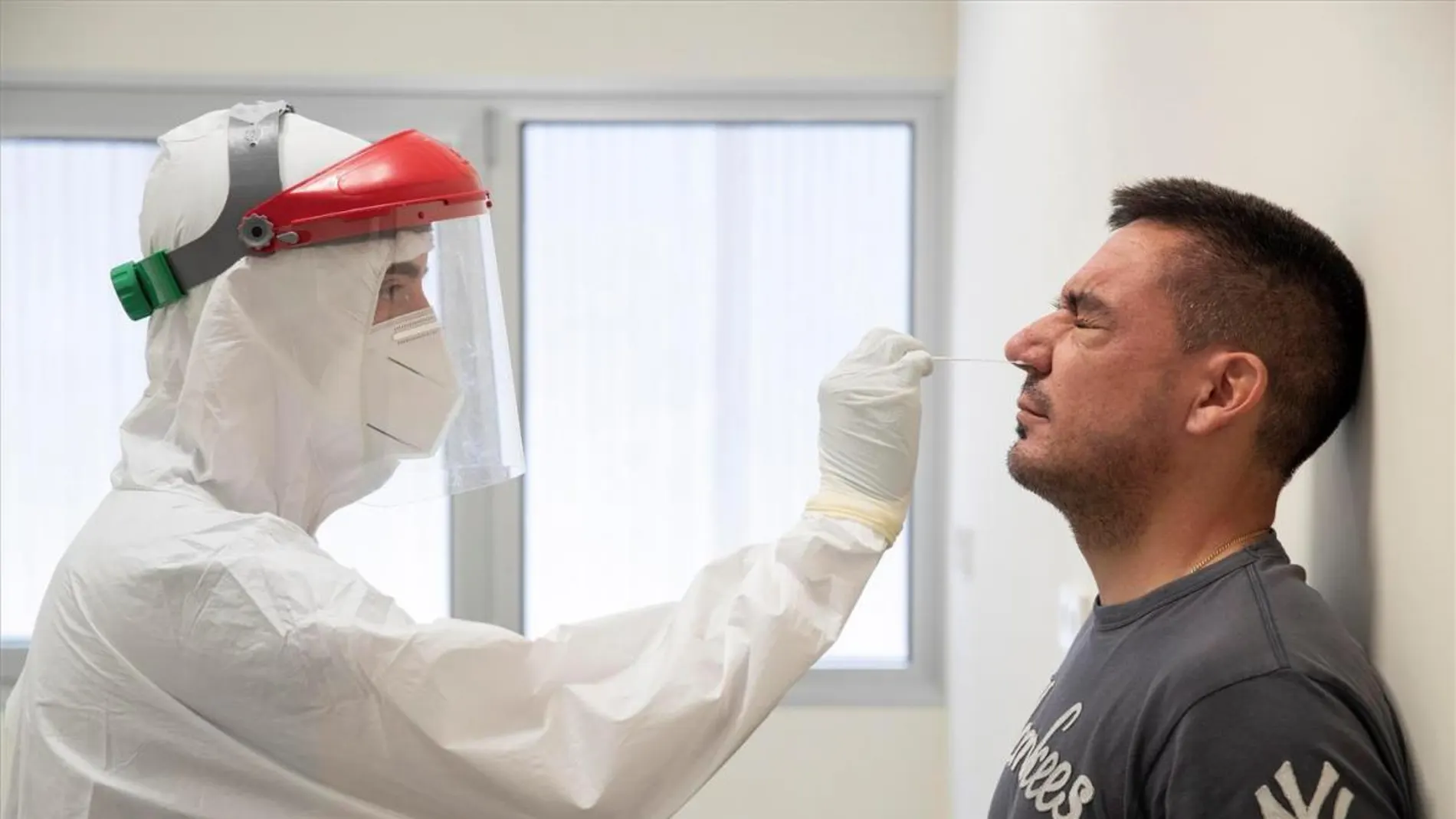 Un sanitario realiza una prueba PCR a un hombre Un sanitario realiza una prueba PCR a un hombre