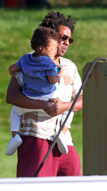 Jay Z con su hijo en brazoo Jay Z con su hijo en brazoo