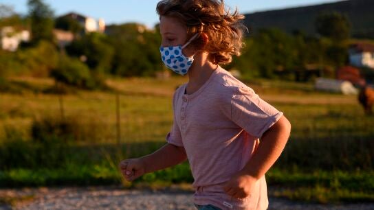 Un ni&ntilde;o con mascarilla juega en la calle