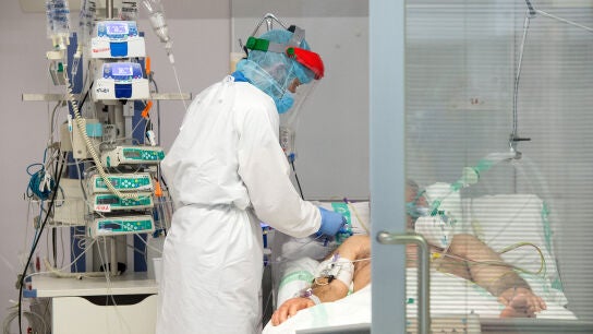 Un sanitario atiende a un paciente de COVID