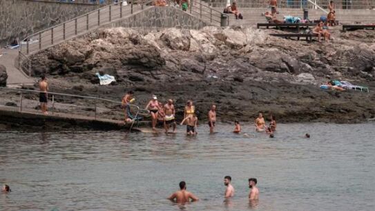 Ba&ntilde;istas en la playa de Arinaga, en el municipio grancanario de Ag&uuml;imes