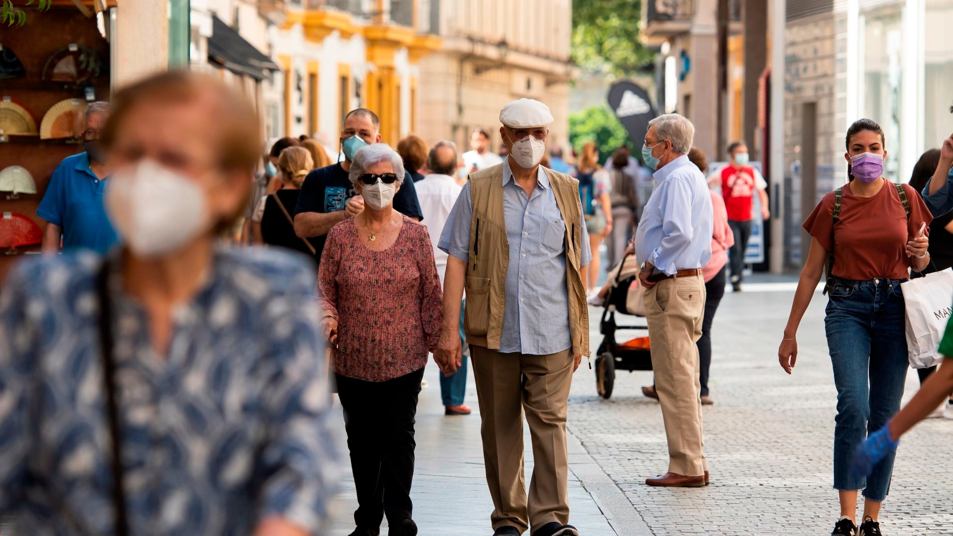 Gente caminando por la calle con mascarilla