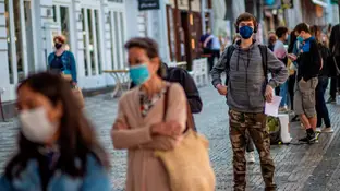 Una cola de gente con mascarillas en una calle de Italia Una cola de gente con mascarillas en una calle de Italia
