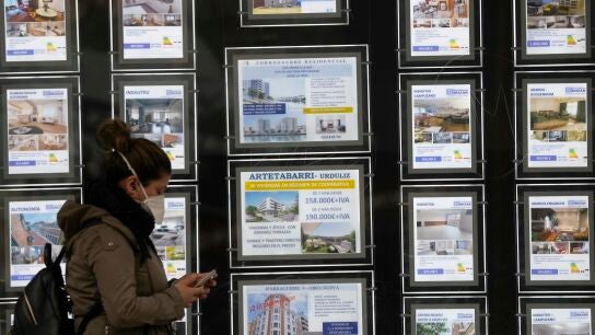 Una mujer pasa por delante de un portal inmobiliario de venta y alquiler
