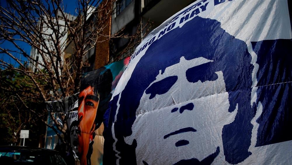 Seguidores despliegan pancartas frente a la clínica donde permanece internado el exfutbolista argentino Diego Maradona