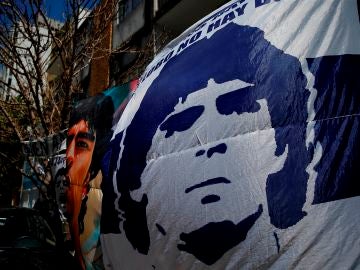 Seguidores despliegan pancartas frente a la clínica donde permanece internado el exfutbolista argentino Diego Maradona
