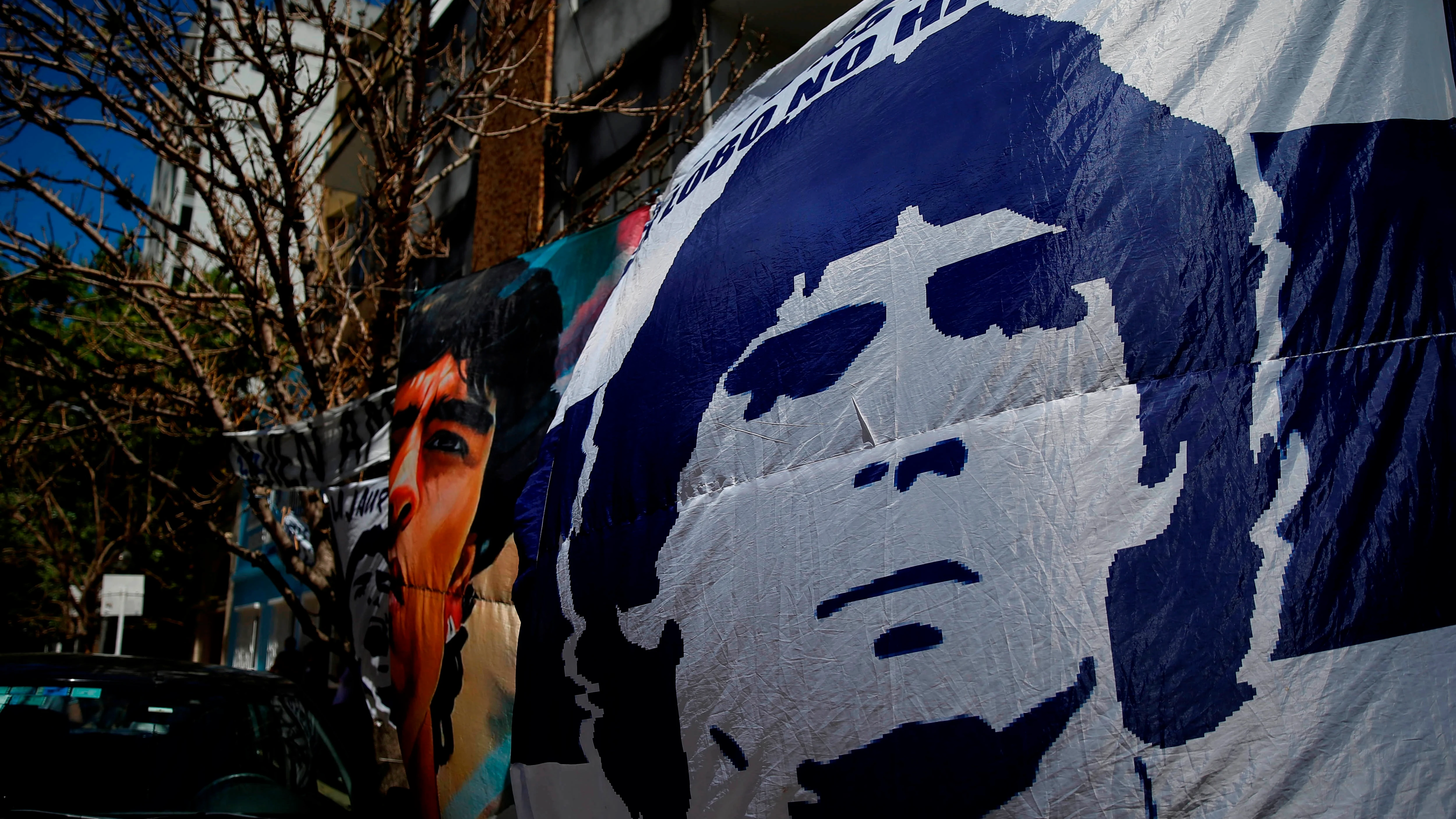 Seguidores despliegan pancartas frente a la cl&iacute;nica donde permanece internado el exfutbolista argentino Diego Maradona