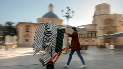 Una persona monta la terraza de un bar de una céntrica plaza de Valencia Una persona monta la terraza de un bar de una céntrica plaza de Valencia