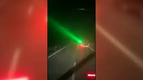 Conductor apunta con un laser en la carrertera Conductor apunta con un laser en la carrertera