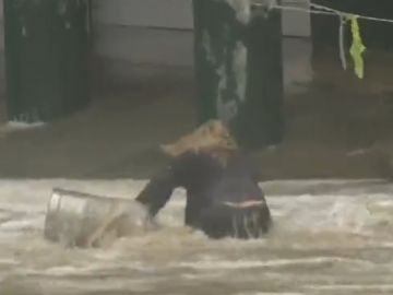 La mujer 'salvando' dos barriles de cerveza arrastrados por el mar