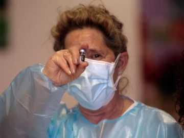 La enfermera muestra la primera dosis de la vacuna contra el coronavirus puesta en España