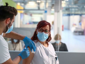 Una enfermera recibe la vacuna contra la COVID-19 en el Hospital Isabel Zendal