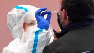 Una enfermera realiza una PCR a otra persona.