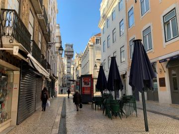 Céntrica calle de Lisboa con las terrazas cerradas