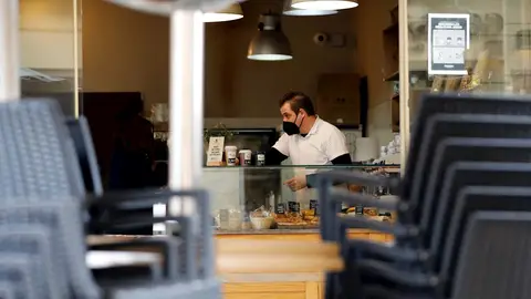 Un hostelero prepara cafés para llevar en una cafetería Restricciones coronavirus