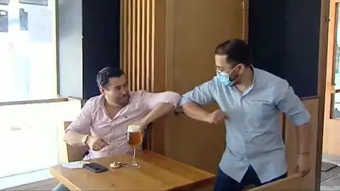 Dos hombres dándose el codo Dos hombres dándose el codo