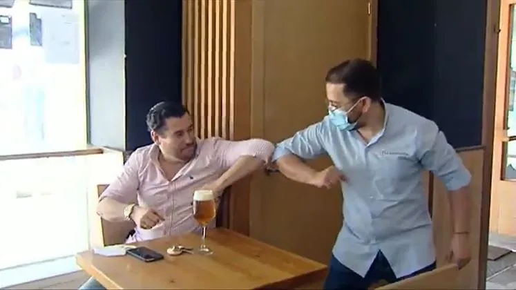 Dos hombres d&aacute;ndose el codo